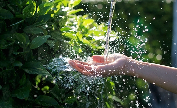 手に水しぶきが当たる様子